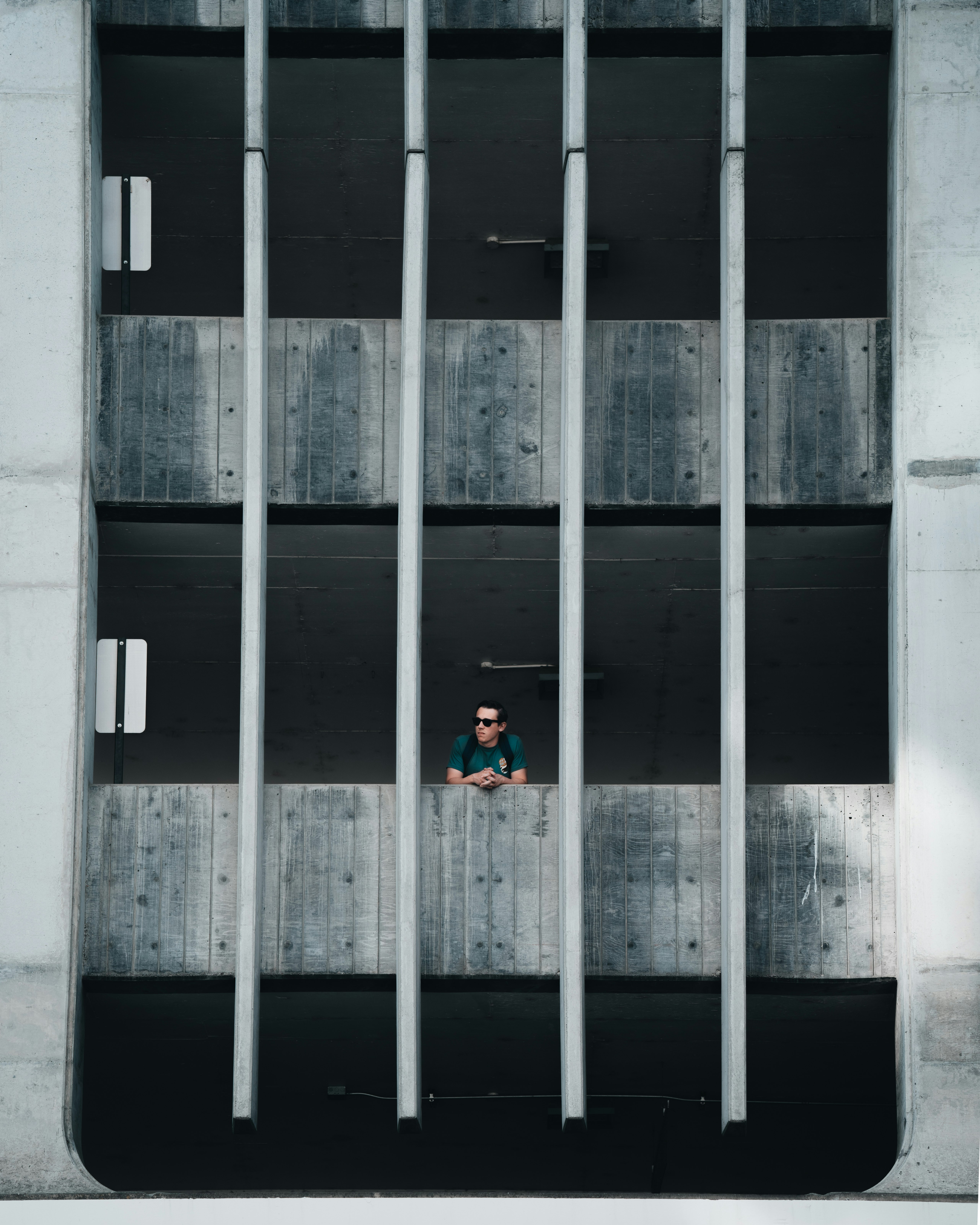 person in red jacket standing on gray concrete floor during daytime